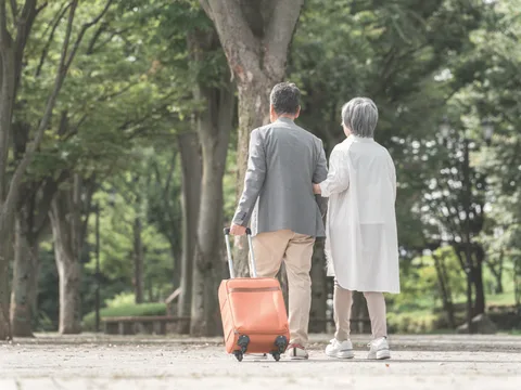 並木道を並んで歩く高齢のご夫婦の後ろ姿